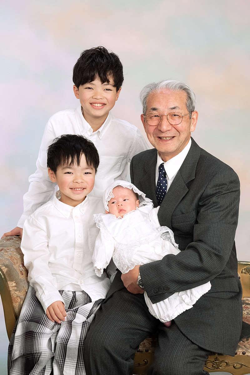 お宮参りの赤ちゃんと兄弟と祖父の写真